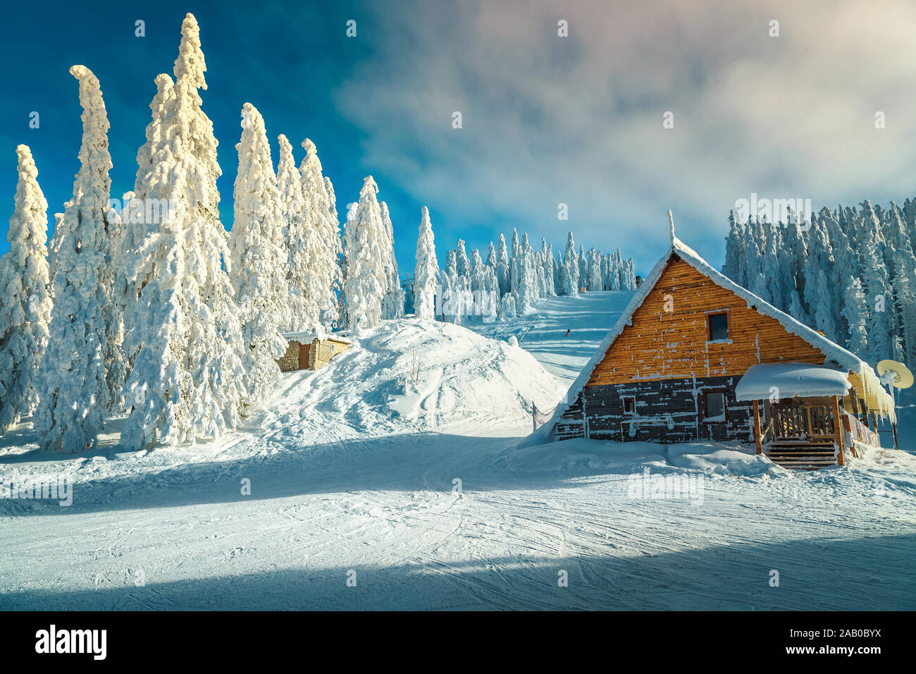 Malerische Winterlandschaft nach Blizzard mit Schnee bedeckt die Pinien. Skipisten und niedlichen Holzhaus in Poiana Brasov Ski Resort, Siebenbürgen, Stockfoto