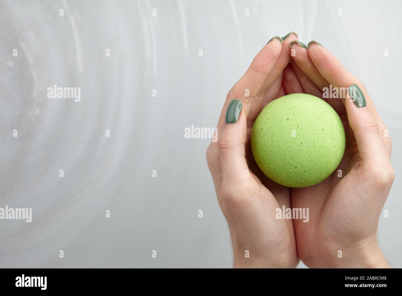 Woman's Hand putting green Badebombe in Wasser, Kopie Raum Stockfoto