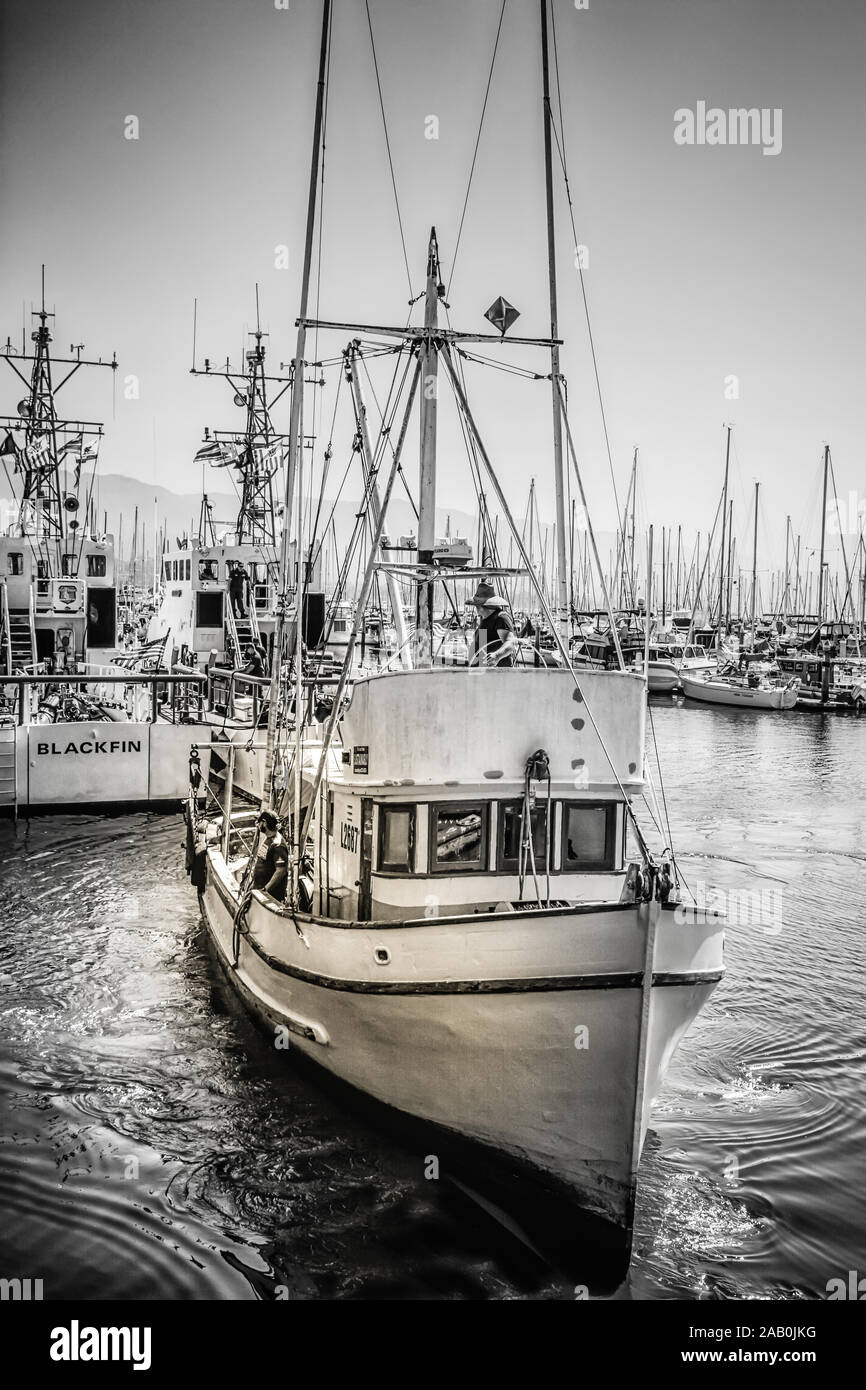 Eine gealterte kommerziellen Fischerboot bringt von den Docks der Marina in den Hafen von Santa Barbara, in Südkalifornien, Schwarz und Weiß Stockfoto