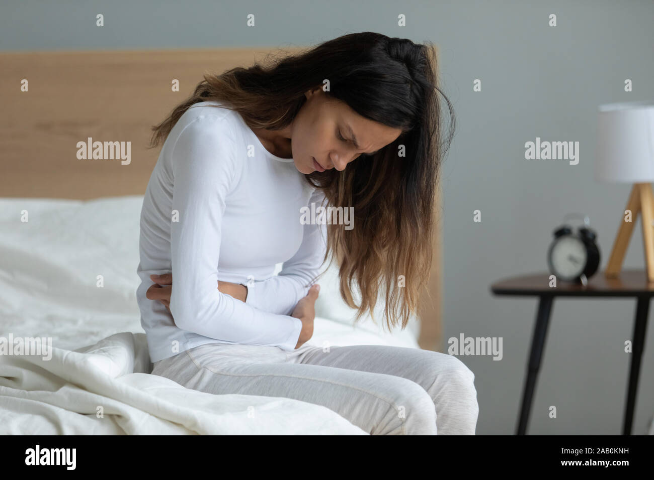 Ungesunde Frau leidet an schweren Kopfschmerzen Bauchschmerzen Stockfoto