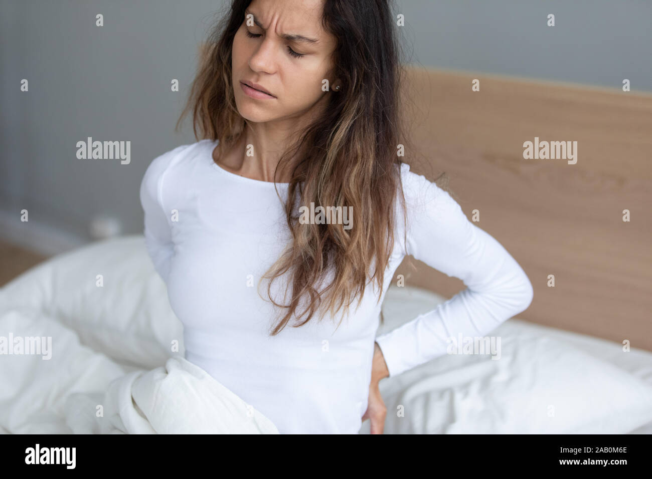 Junge Frau erwachen Gefühl, Schmerzen im unteren Rücken Stockfoto