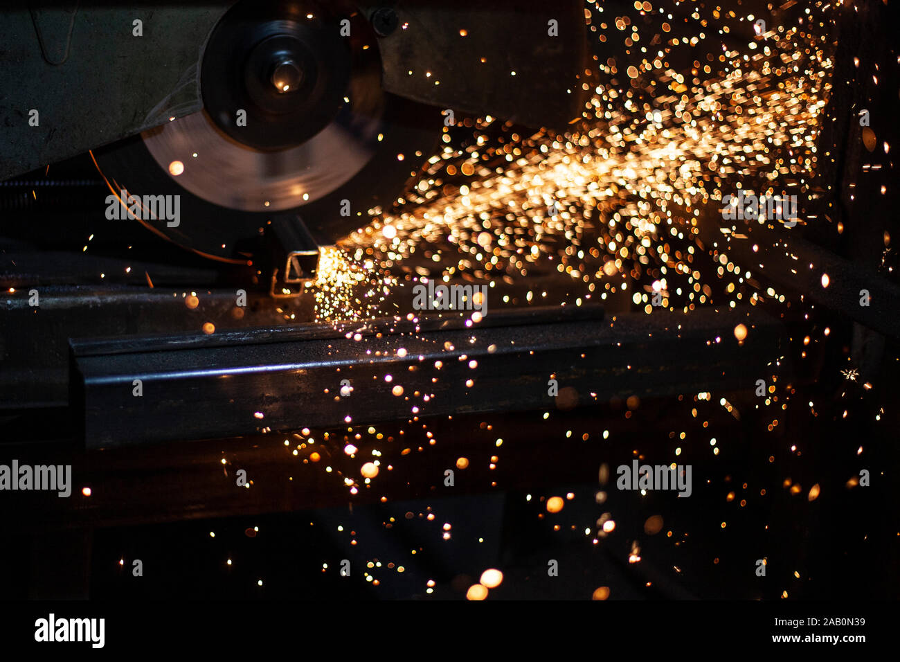 Ein Mann Poliermittel für Metall in eine Werkstatt. Schaffung einer Werbe-Struktur. Metallrahmen in der Garage. Funken aus Metall schneiden. Lebendige blinkt er Split Stockfoto