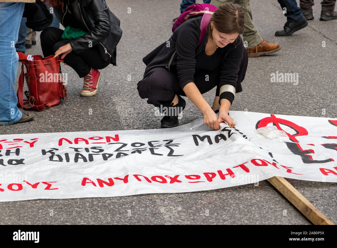 Eine kommunistische Partei KKE-Unterstützer, die Festsetzung eines Demonstranten Banner auf oktovriou Av nächste Die Polytechnio der Universität. Stockfoto