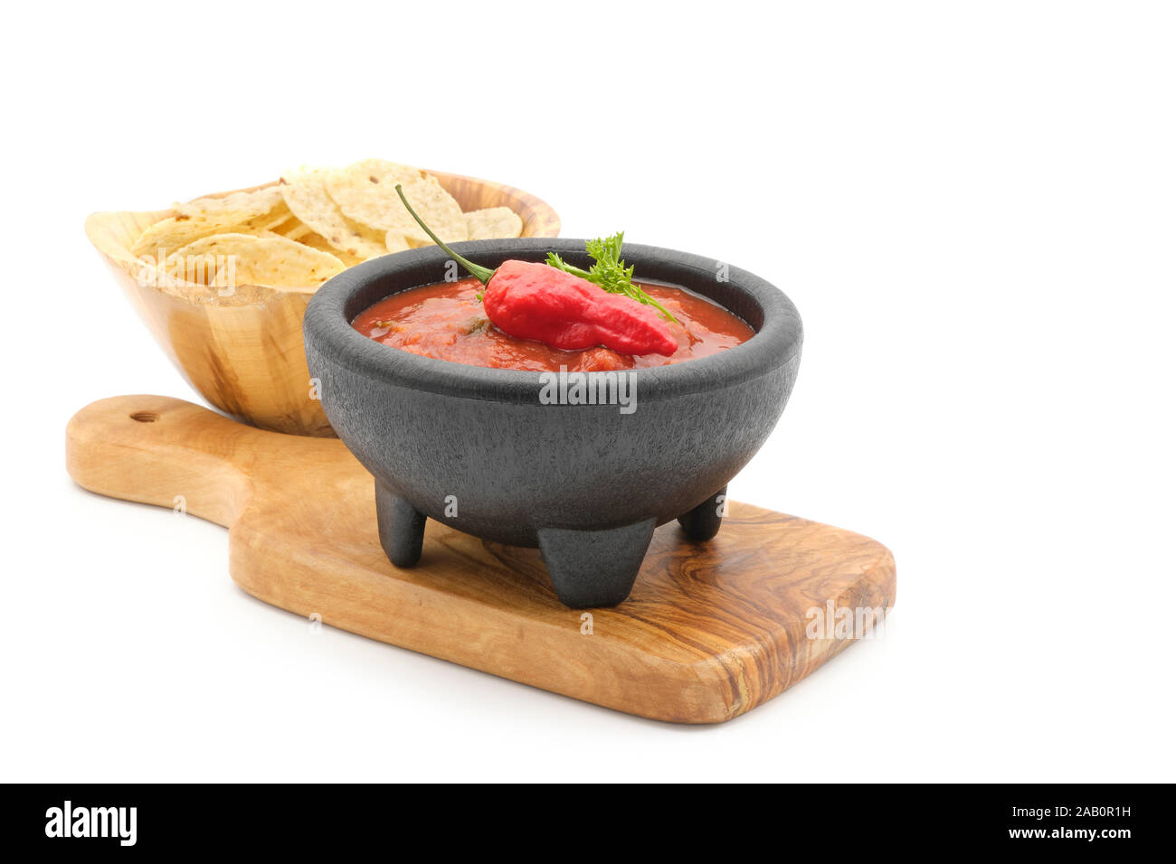 Schüssel scharfe rote Salsa mit Tortilla Chips auf einem weißen Hintergrund. Stockfoto