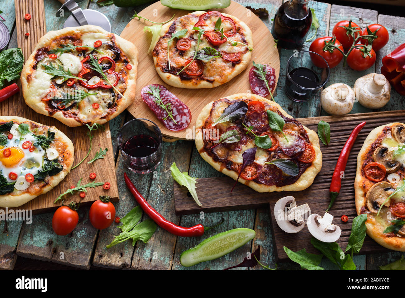 Blick von oben auf die frisch prerared leckere Pizzen. Italienische rustikale Pizza mit Eier, Salami, Pilze und Gemüse mit rohen Zutaten serviert. Stockfoto