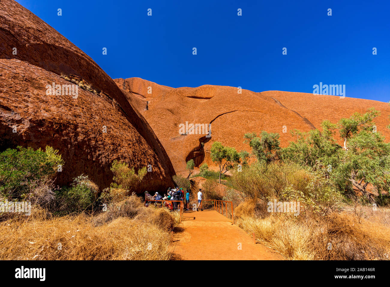 Touristen entlang einem Ranger geführten Mala Spaziergang zum Kantju Gorge Mala Parkplatz am Fuße des Uluru (Ayres Rock). Northern Territory, Australien Stockfoto