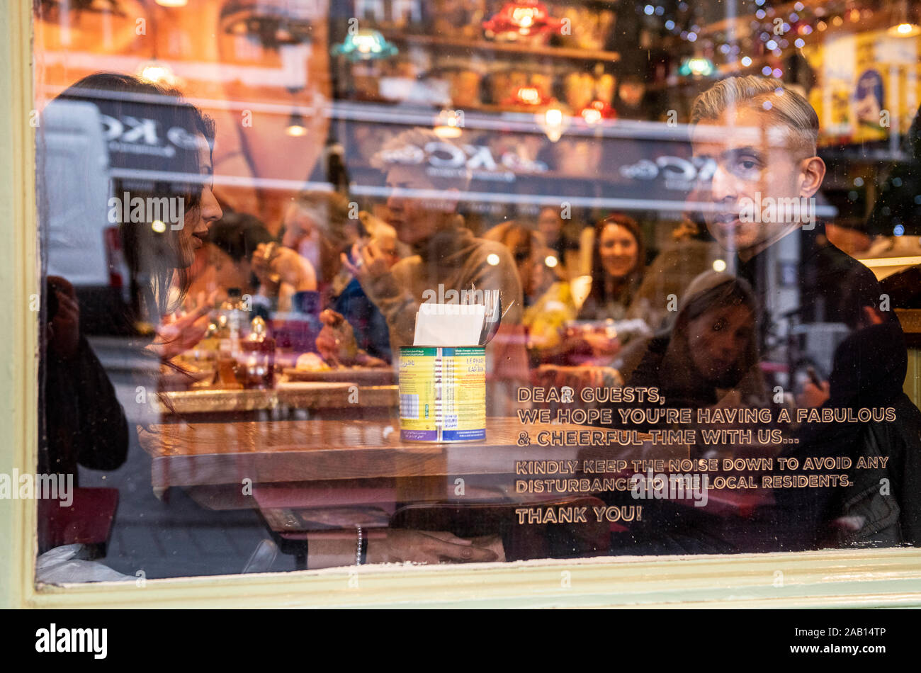 Kunden durch Fenster in busy cafe Mittagessen sitzen. South Kensington, London, England, UK. Stockfoto