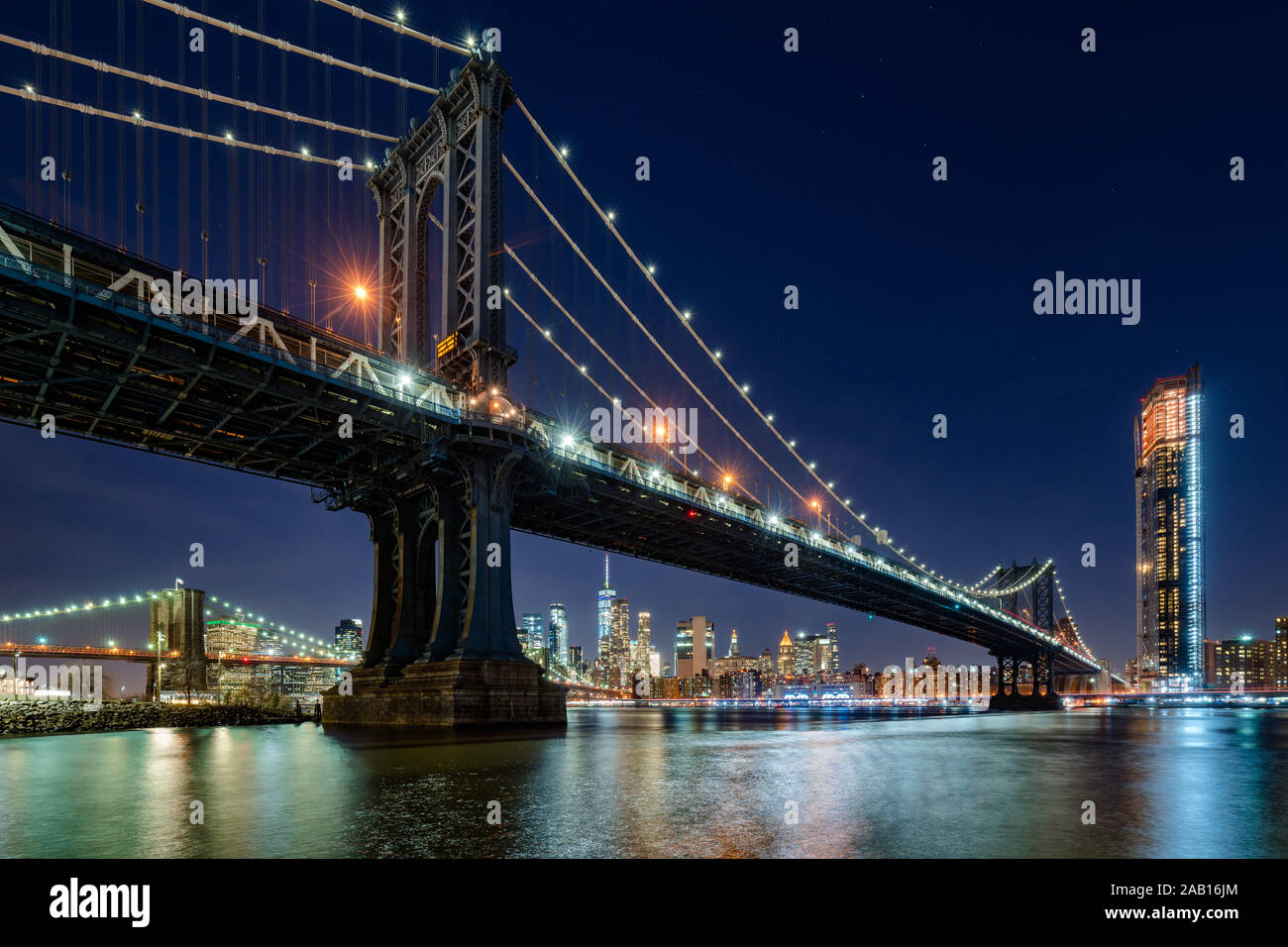 Nacht Blick auf die Manhattan Bridge aus Brooklyn Main Street Park mit Wolkenkratzer von Manhattan im Hintergrund. New York City, NY, USA Stockfoto