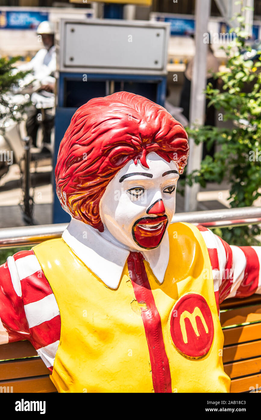 Indien, Bengaluru City, Ronald McDonald Sitzbank, Grüße an alle Kunden, Maskottchen für Kinder, gelb M Symbol von McDonald Restaurant Stockfoto