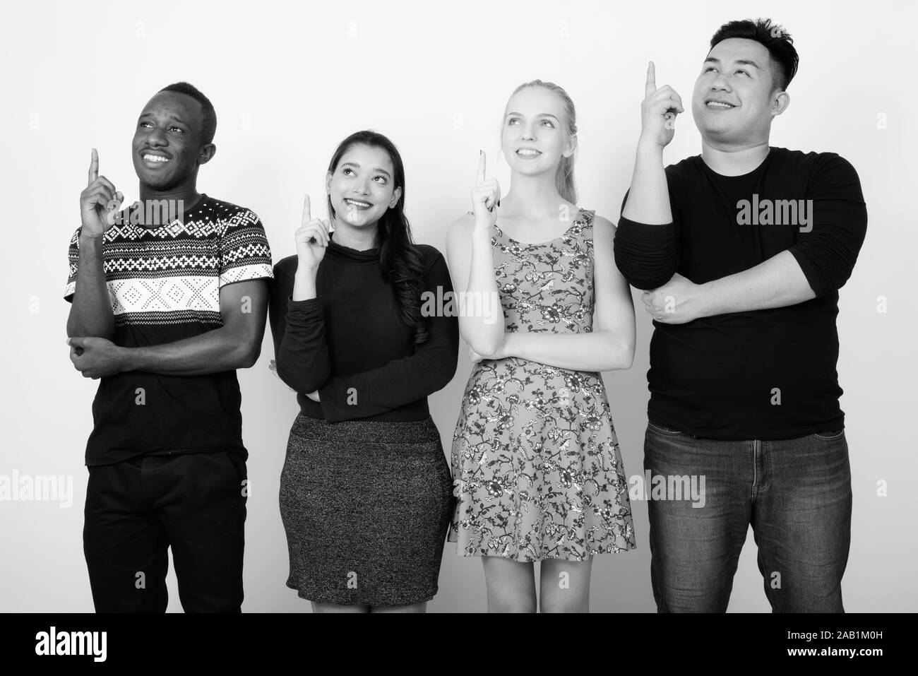 Studio shot von Happy vielfältige Gruppe von multi-ethnische Freunden lächeln und denken, während Finger zusammen, Stockfoto