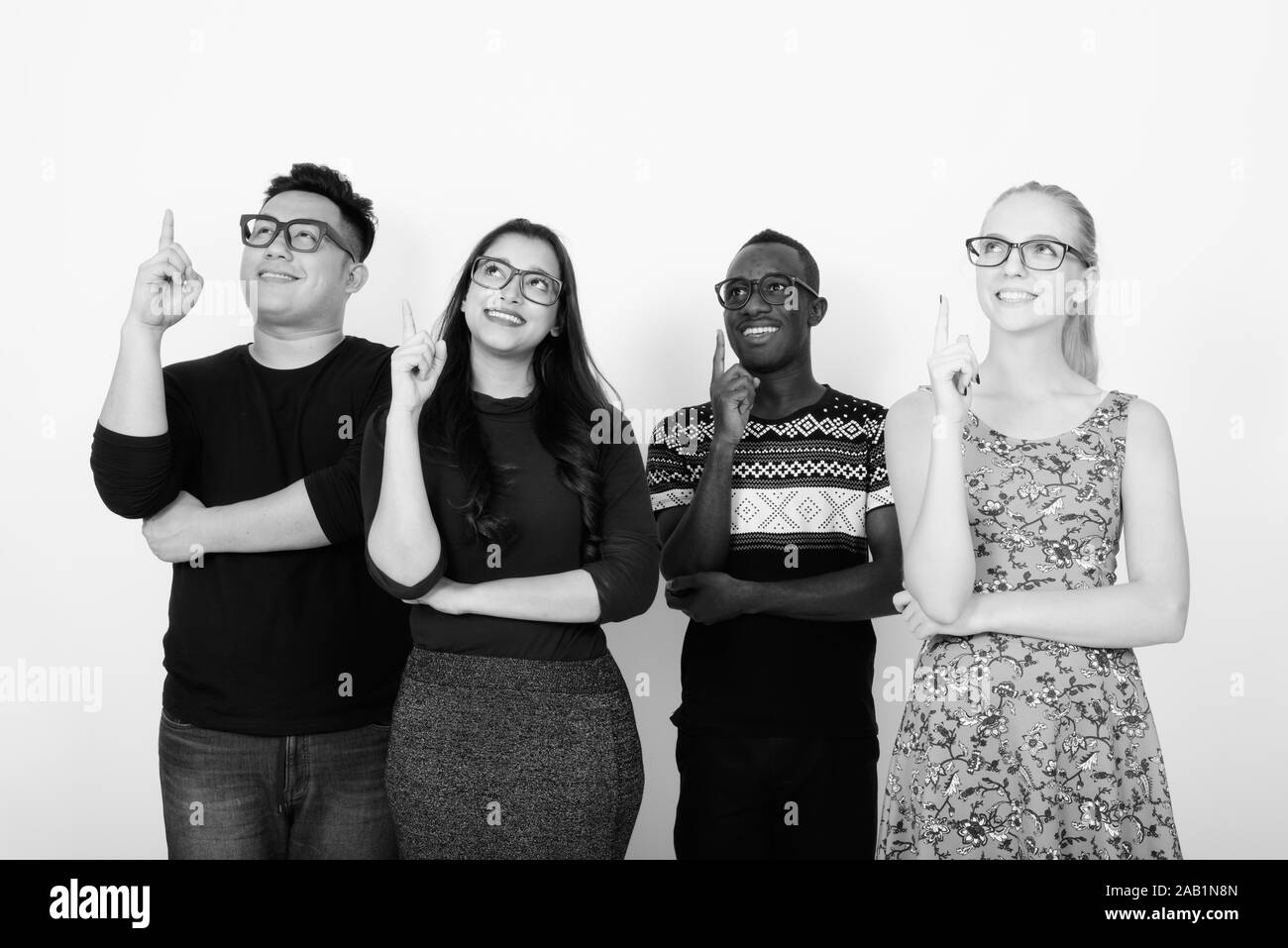 Studio shot von Happy vielfältige Gruppe von multi-ethnische Freunden lächeln und denken, während Finger nach oben mit Brillen zusammen Stockfoto