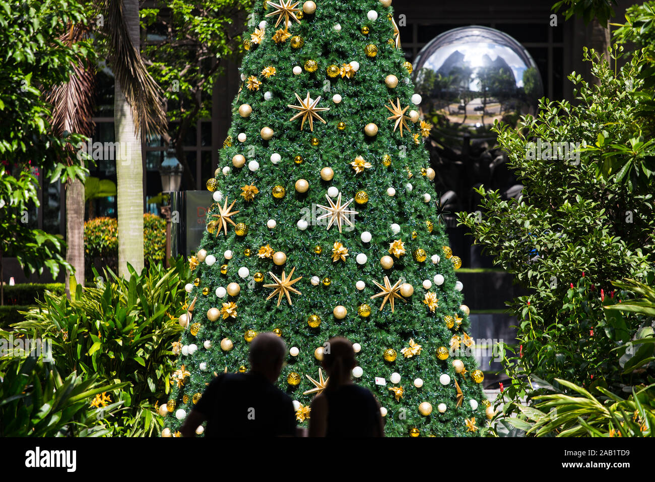 Zwei Menschen in Silhouette stehen vor dem Weihnachtsbaum im heißen tropischen Klima in Singapur, Südostasien. Stockfoto