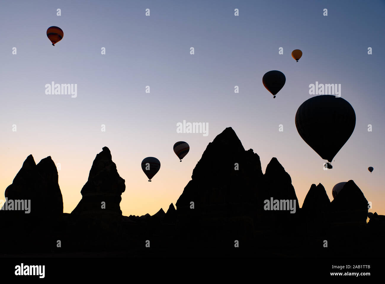 Silhouette von fliegenden Heißluftballons und Rock Landschaft bei Sonnenaufgang in Göreme, Kappadokien, Türkei Stockfoto