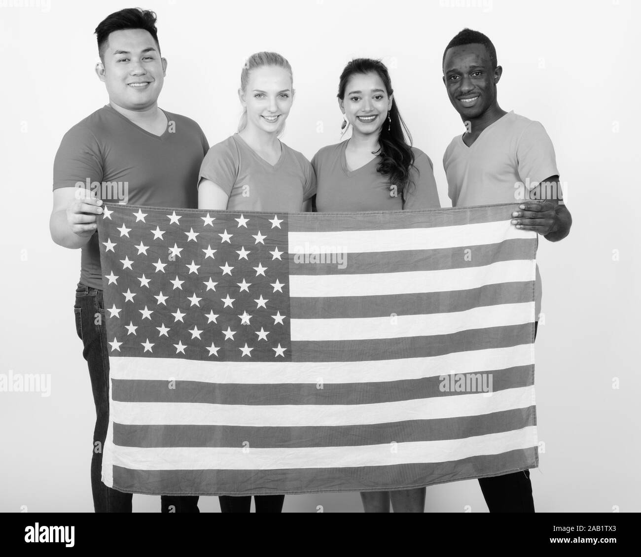 Studio shot von Happy vielfältige Gruppe von multi-ethnische Freunde lächelnd, während die amerikanische Flagge zusammen halten Stockfoto