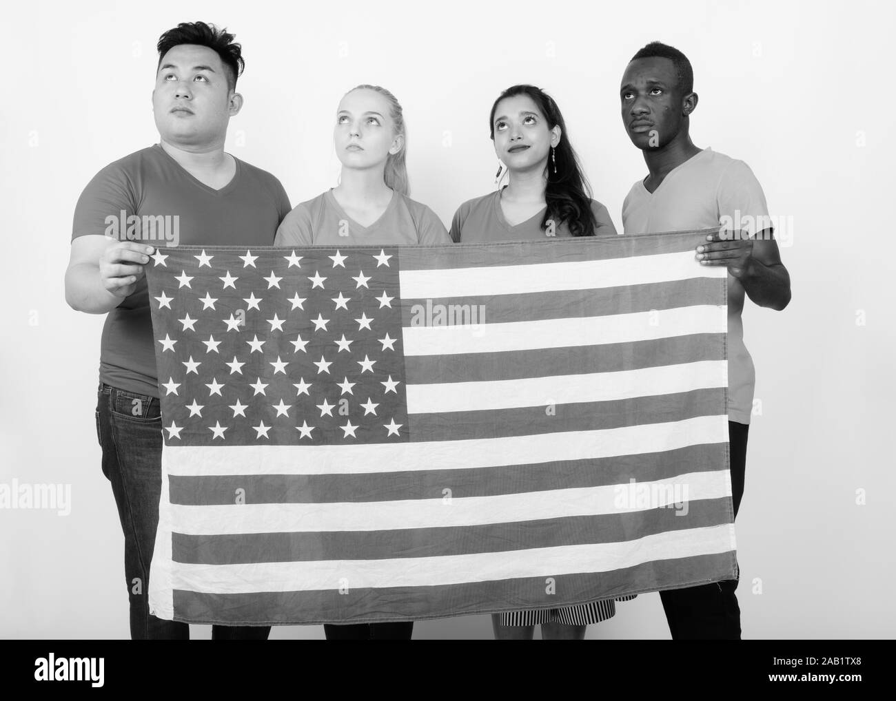 Studio Aufnahme der vielfältigen Gruppe von multi-ethnische Freunde denken, während die amerikanische Flagge zusammen halten Stockfoto