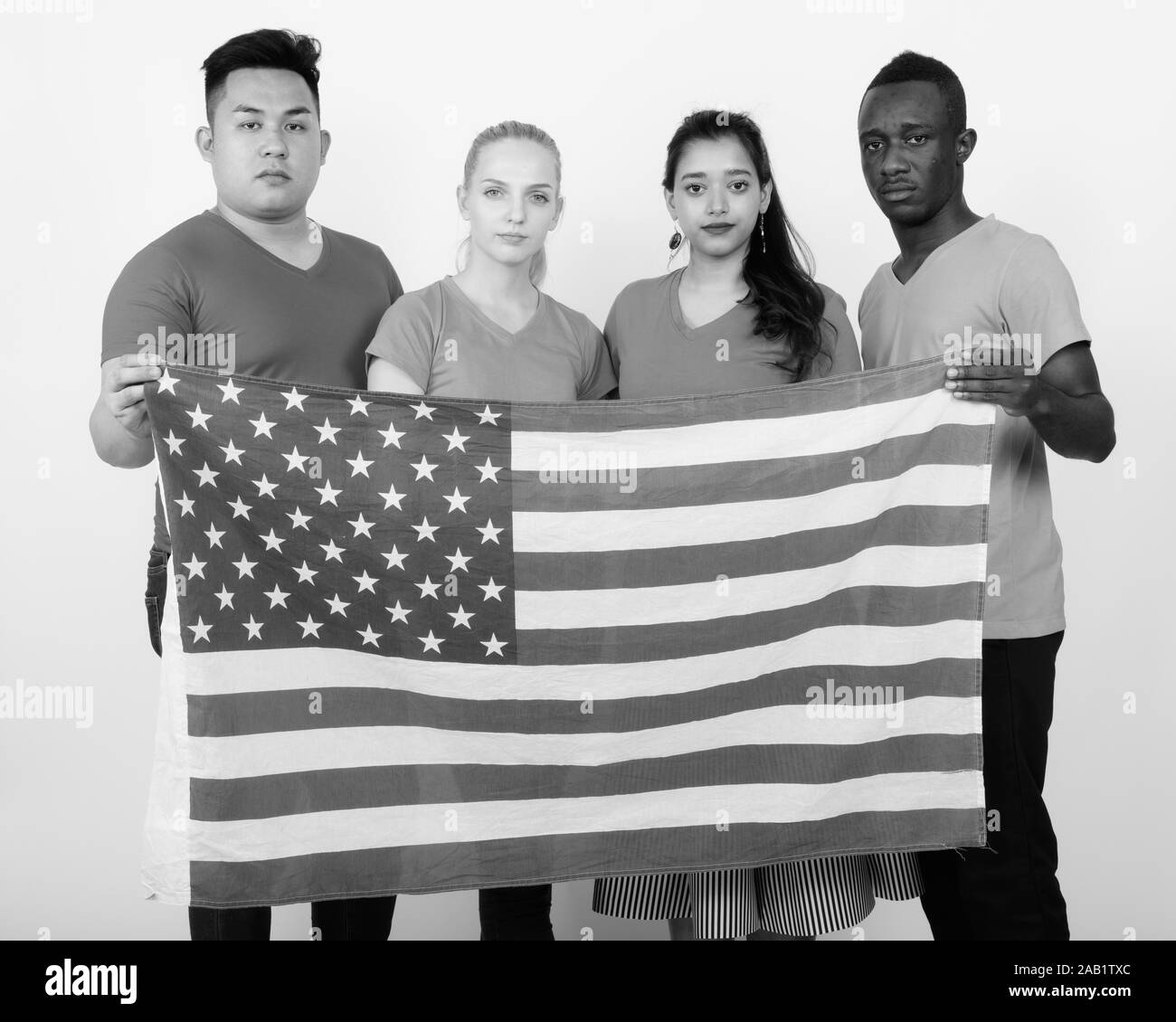 Studio Aufnahme der vielfältigen Gruppe von multi-ethnische Freunde halten Sie die amerikanische Flagge zusammen Stockfoto