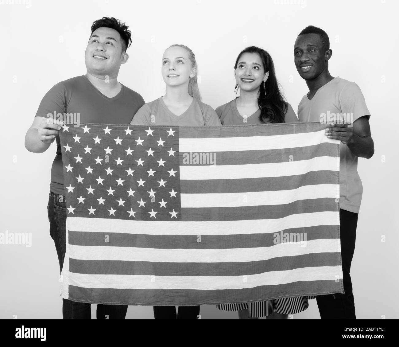 Studio shot von Happy vielfältige Gruppe von multi-ethnische Freunden lächeln und denken, während die amerikanische Flagge zusammen halten Stockfoto