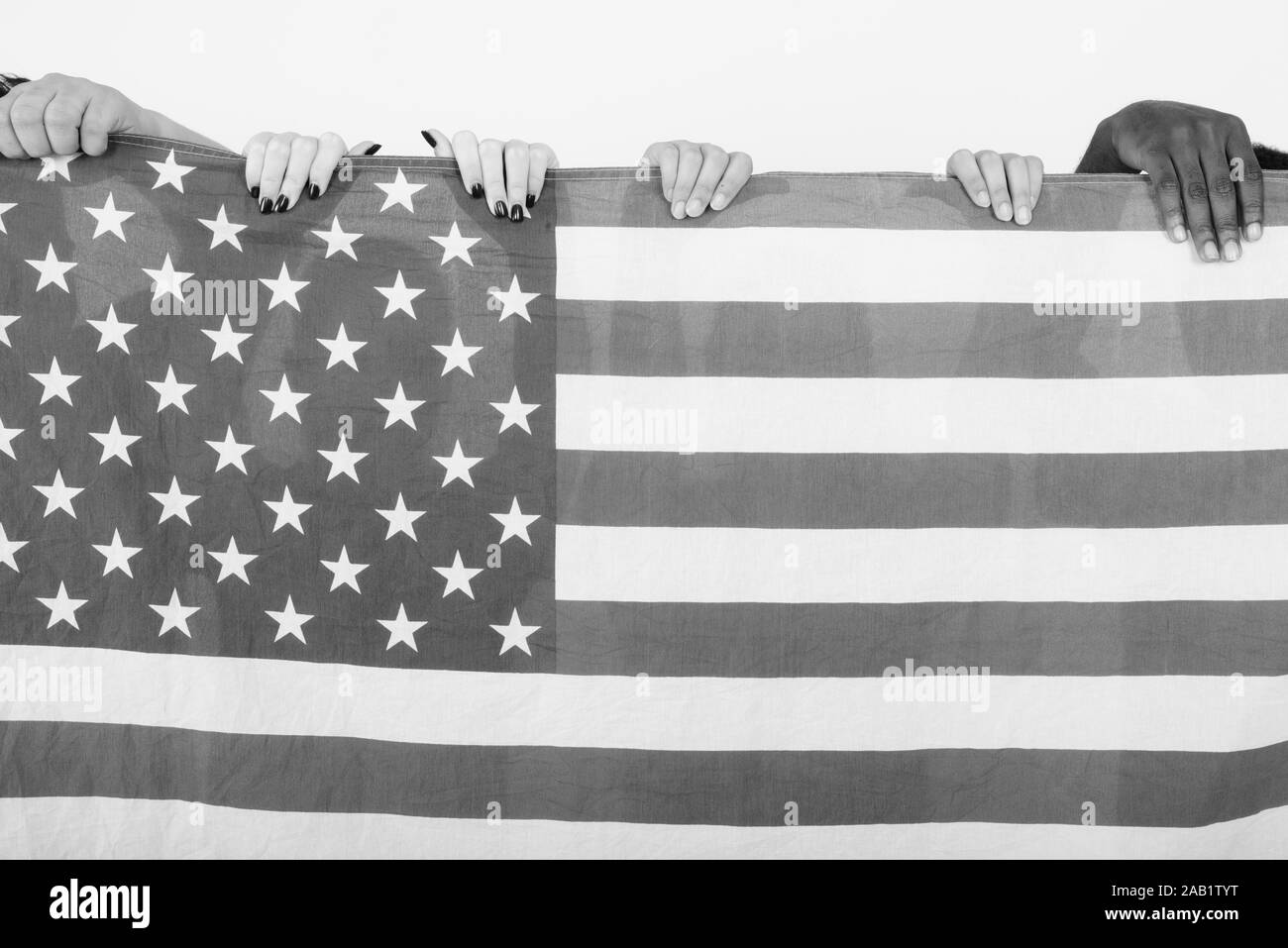Studio shot der amerikanischen Flagge mit vielfältigen Gruppe von multi-ethnische Freunde zusammen halten als Symbol für Einheit und Vielfalt Stockfoto
