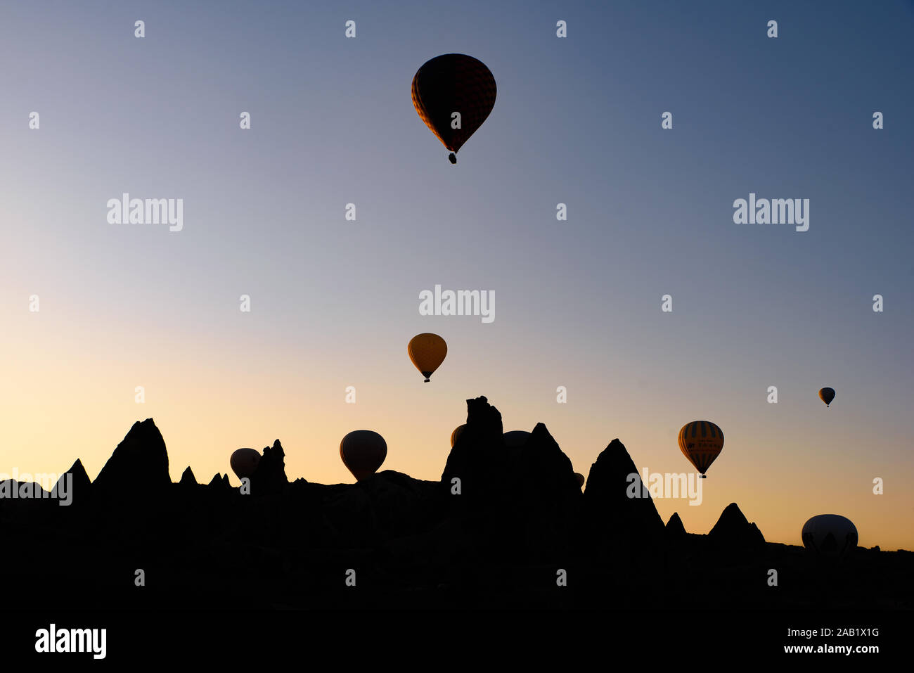 Silhouette von fliegenden Heißluftballons und Rock Landschaft bei Sonnenaufgang in Göreme, Kappadokien, Türkei Stockfoto