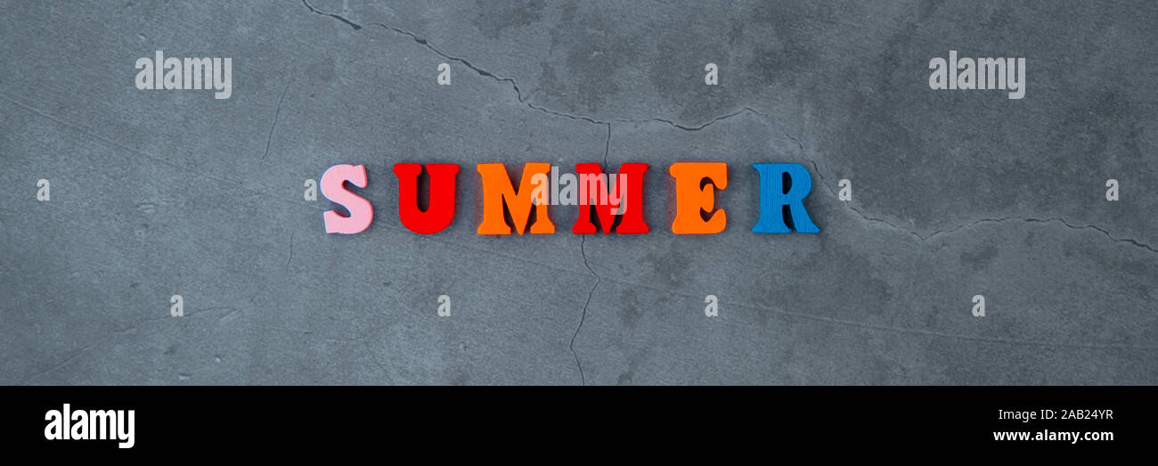 Die bunten Sommer Wort ist aus Holz Buchstaben auf einem grau verputzte Wand Hintergrund gemacht Stockfoto