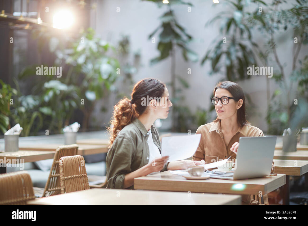 Porträt von zwei jungen Unternehmerinnen diskutieren Projekt am Tisch sitzen in Designer Cafe, kopieren Raum Stockfoto