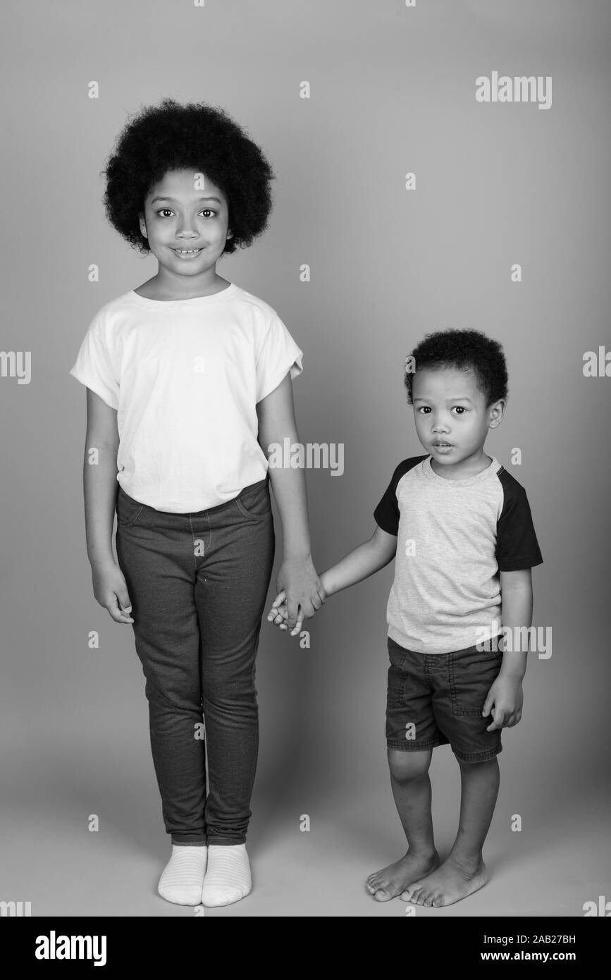 Junge niedlichen Afrikanischen Geschwister zusammen in Schwarz und Weiß Stockfoto