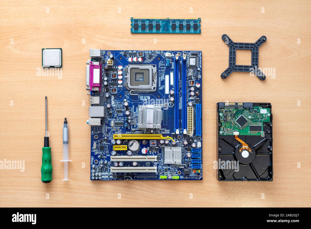 Hauptplatine, Prozessor, Speicher, Festplatte, Schraubendreher und Wärmeleitpaste auf den Tisch. Das Konzept der Montage computer. Ansicht von oben, flach. Stockfoto