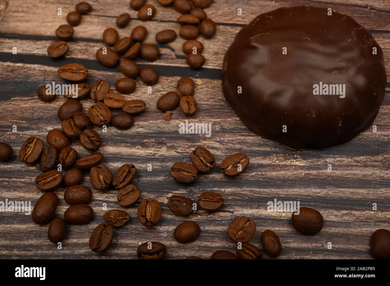 Marshmallow in Schokolade und Kaffee Bohnen auf Holz- Hintergrund. Nahaufnahme Stockfoto