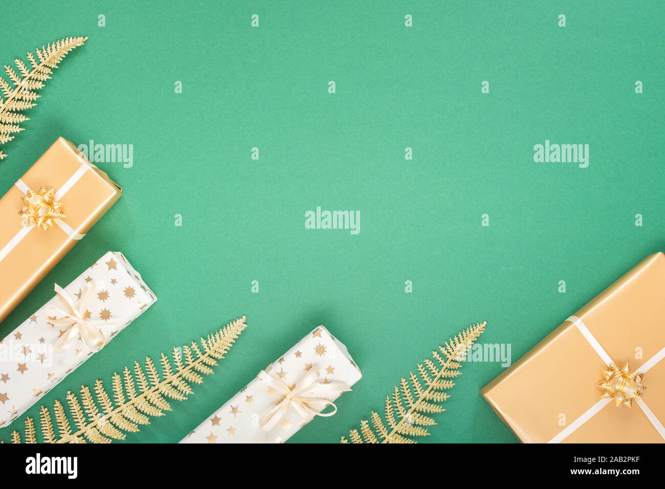 Festliche grüner Hintergrund mit gold Dekoration, Hintergrund mit Glitzer glänzenden goldenen Farnblätter und Geschenkboxen, Flach, Ansicht von oben, kopieren Raum Stockfoto