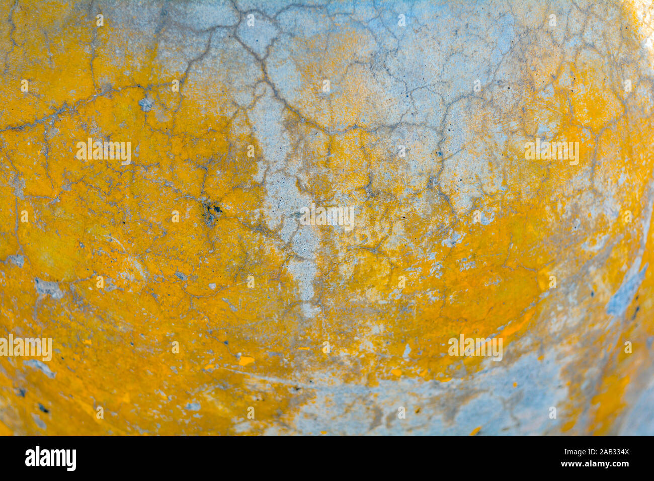 Gelb und Grau gerissenen Beton Textur. Raue Oberfläche mit Gelb lackiert Flecken. Alte verwitterte gemalten Hintergrund Textur Stockfoto