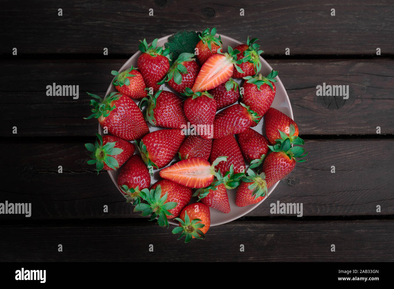 Frische rote Erdbeeren auf einem Kreis. Dunklen Hintergrund Stockfoto