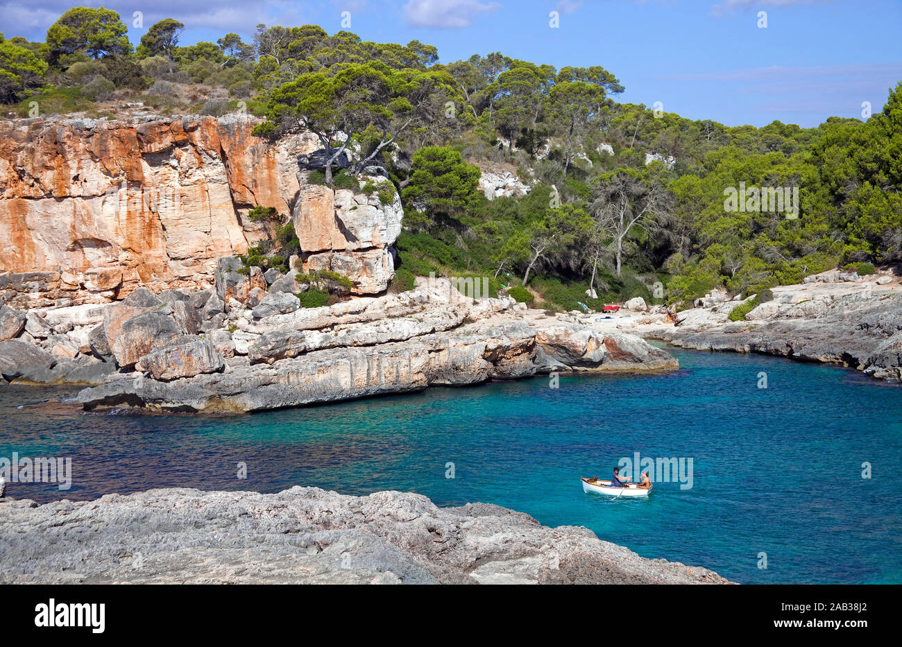 Ruderboot an der felsigen Küste von Cala S'Almonia, Naturpark Cap de Ses Salines, Cala Llombards, Mallorca, Balearen, Spanien Stockfoto