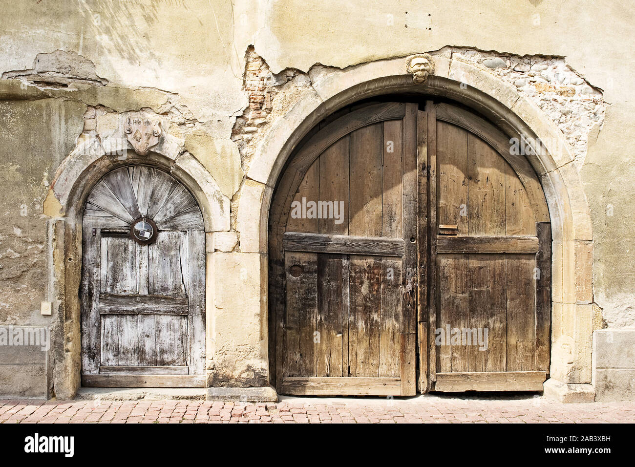 Hausfront mit einem alten Hauseingang und Tor | Vor dem Haus mit einer alten Tür und Tor | Stockfoto