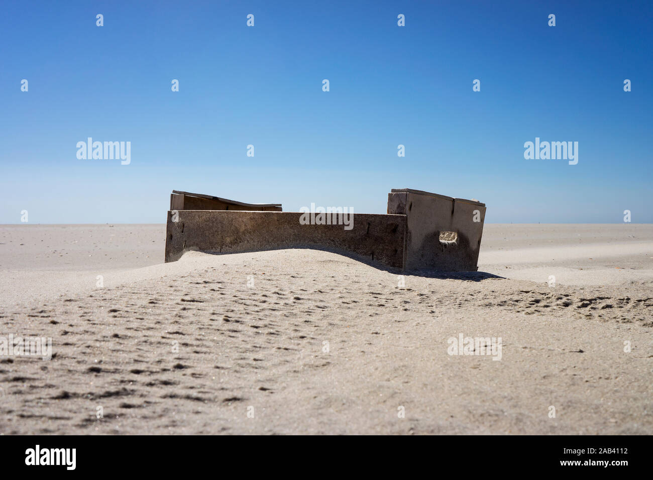 Eine angespülte Holzkiste auf einer Sandbank im Watt vor St. Peter Ording | EINE hölzerne Kiste angespült auf einer Sandbank im Schlamm vor St. Peter Gewöhnlichen Stockfoto