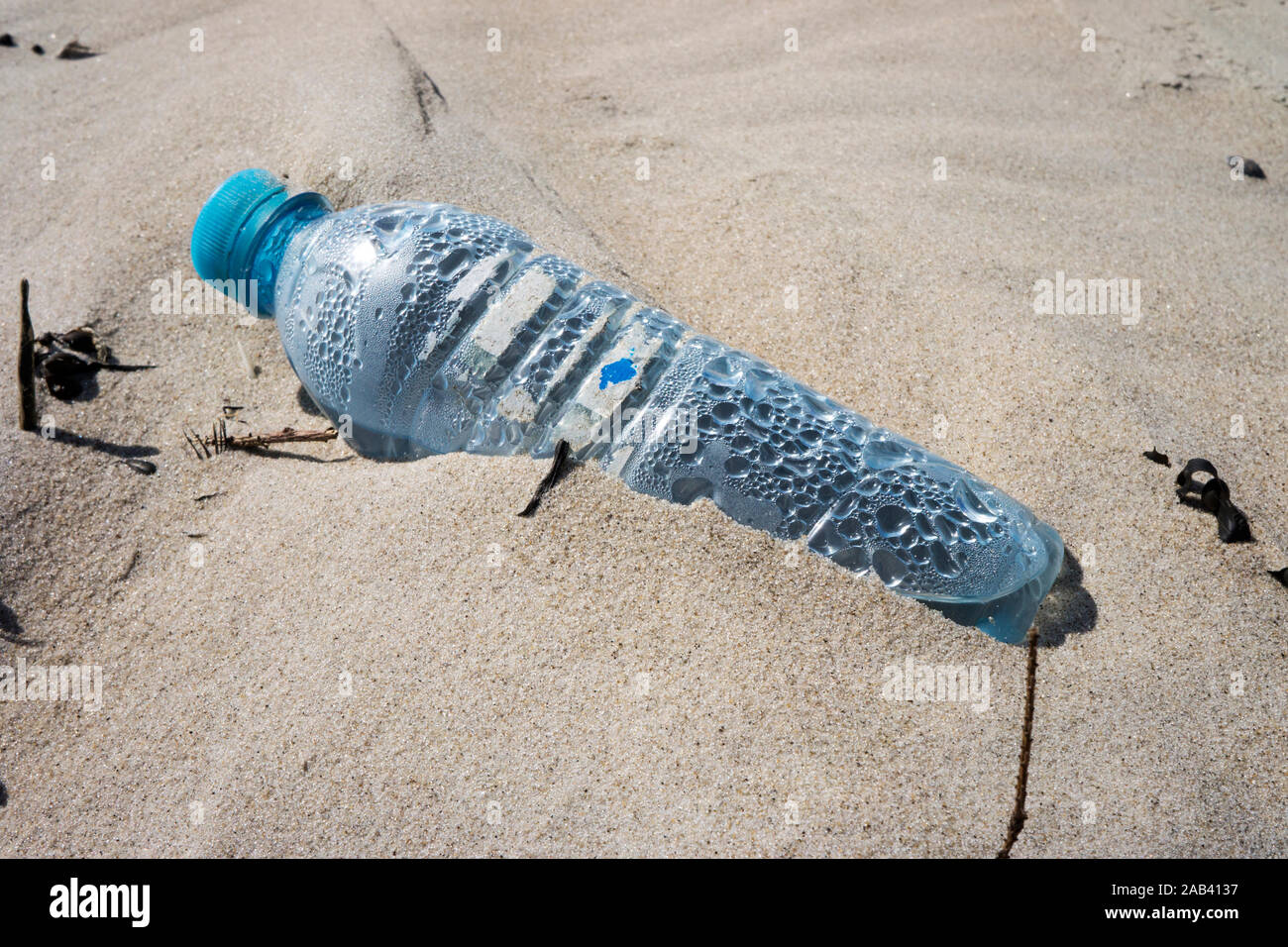 Eine angespülte Mineralwasserflasche aus Kunststoff auf einer Sandbank im Watt | Eine Flasche Mineralwasser aus Kunststoff auf einer Sandbank in der Wad Stockfoto