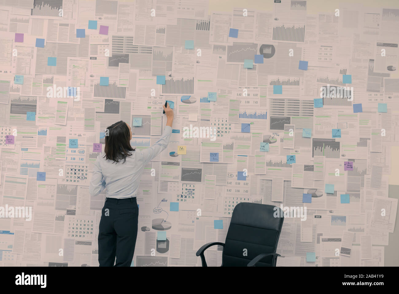 Die Geschäftsfrau, die Überprüfung der finanziellen Daten und Berichte an der Wand aufhängen, Management und Strategie Konzept Stockfoto