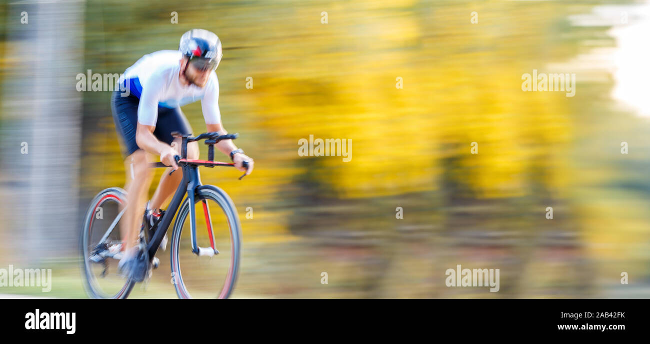 Panning schoss der Sportler mit dem Fahrrad im Herbst Park. Geschwindigkeit Radfahren blur Hintergrund Stockfoto