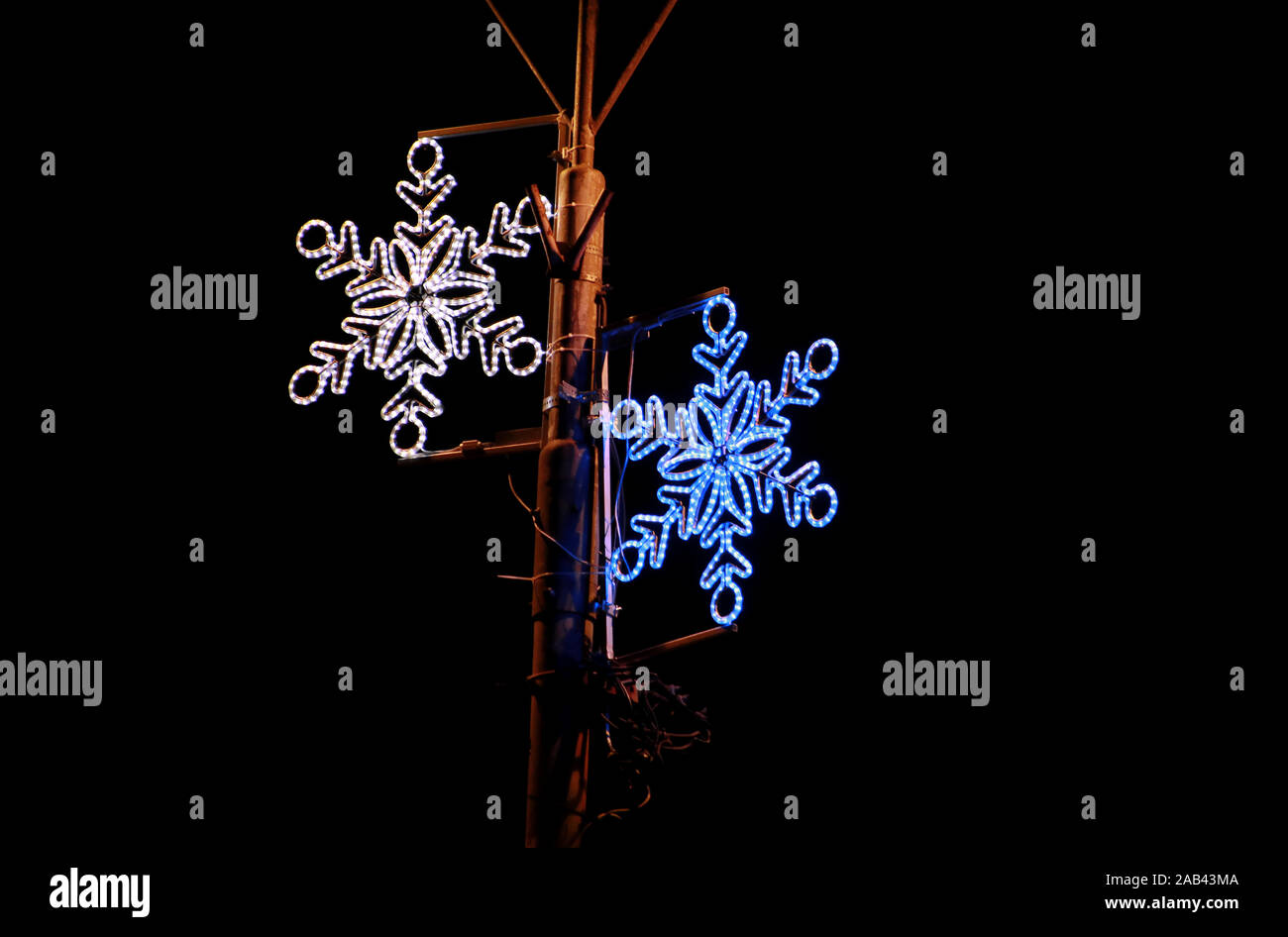 Weihnachten blau und weiße Lichter Simulation Form von gefrorenen Schneeflocken. Straße Detail des Neuen Jahres und Weihnachtsschmuck, string Reis Glühlampen. Stockfoto