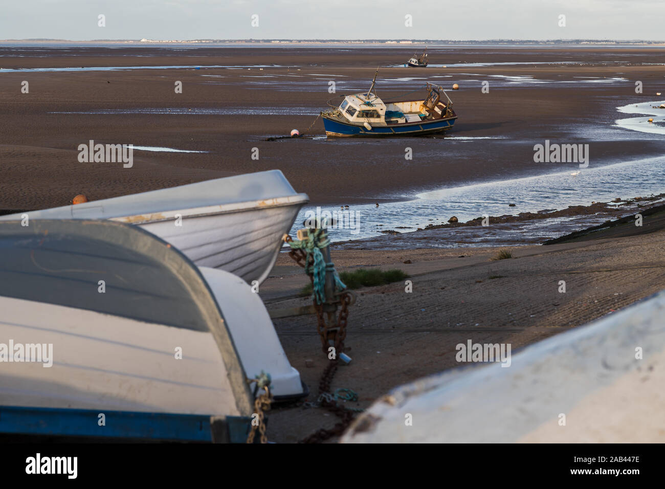 Umgedrehten Boote im Vordergrund Rahmen aufrechter eine am Strand von meols auf dem Wirral in der Nähe von Liverpool im November 2019. Stockfoto