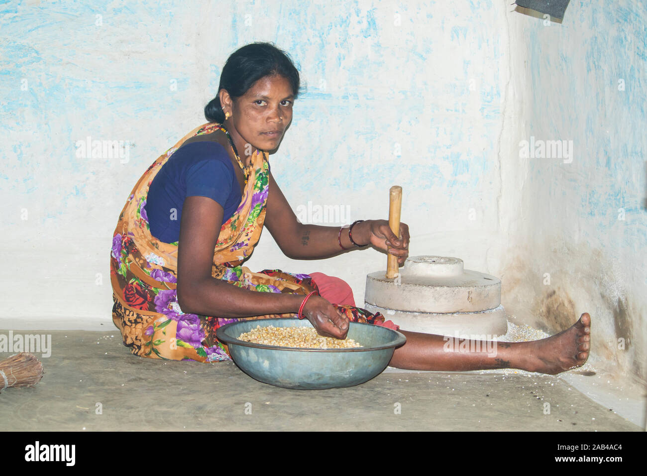 Sijhora, Madhya Pradesh, Indien - November 2019: Ländliche indische Frau mit der Mühle mahlen, Sijhora Madhya Pradesh Indien Mais. Stockfoto