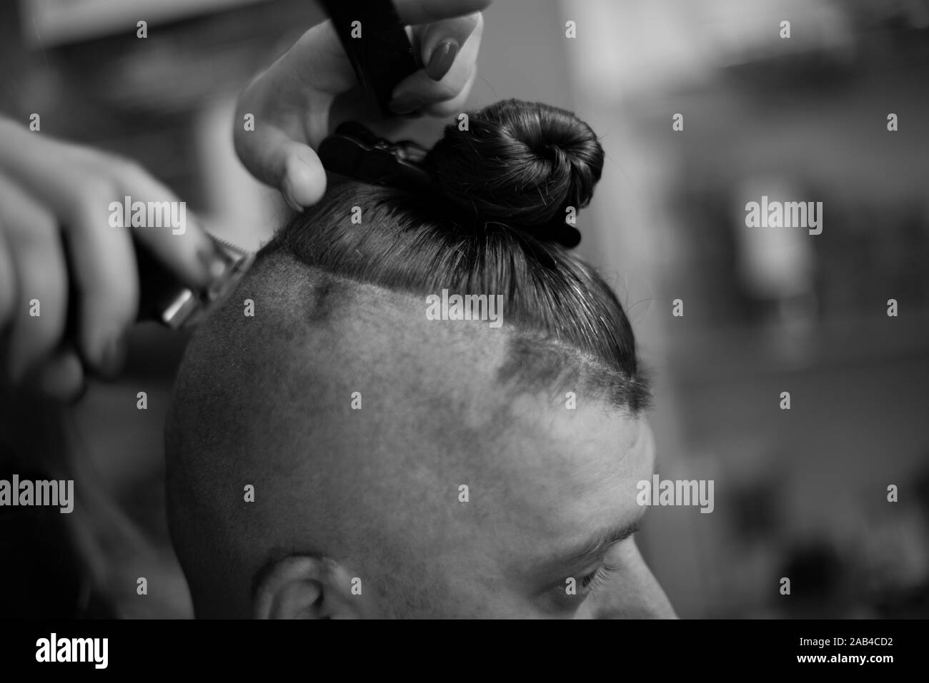 Männliche Hipster in barbershop Friseur auf modischen Haarschnitt. Ein Mann schneidet sich die Haare und Bart beim Friseur. Männer Haarschnitt. Beauty Salon. Schwarz und wh Stockfoto