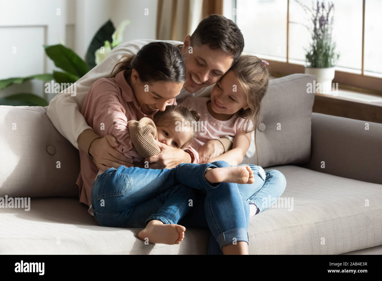 Glückliche Eltern Spaß mit niedlichen Kinder Töchter knuddeln Kitzeln Stockfoto