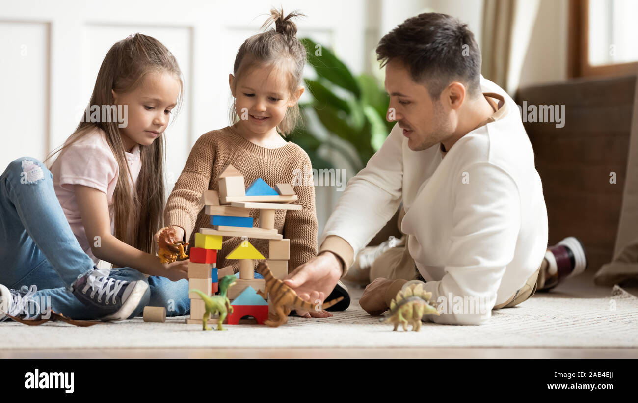 Pflege junger Vater und kleinen Töchter zusammen zu Hause spielen Stockfoto