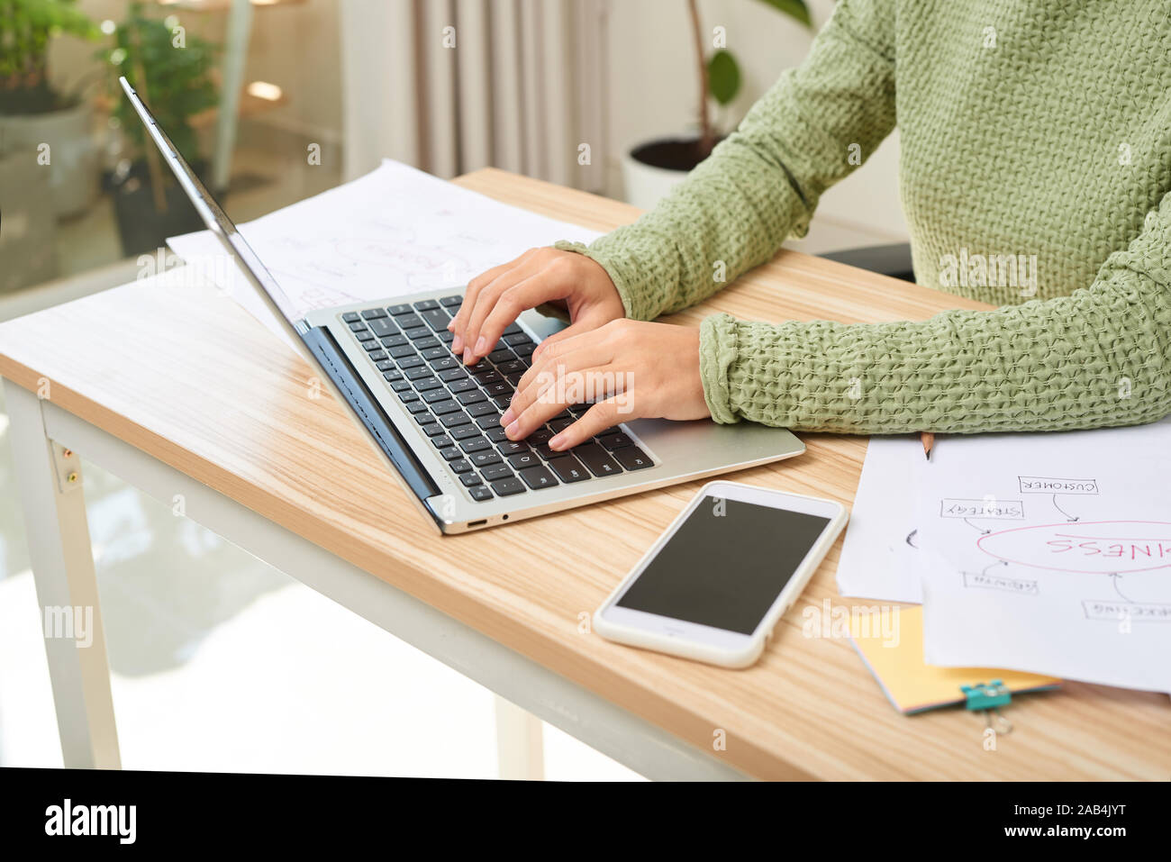 Junge weibliche Unternehmer Arbeiten am Schreibtisch Texteingabe auf Ihrem Laptop in einem Home Office Stockfoto