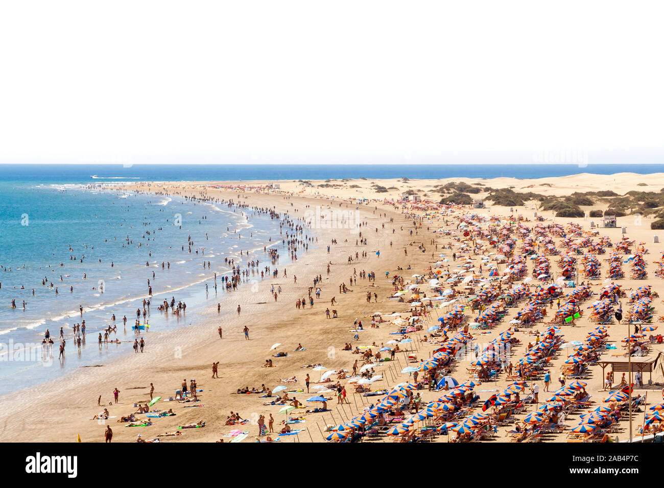 Eine Menge Leute in den berühmten Strand "Playa del Ingles' in Maspalomas, Kanarische Inseln. Weißen Himmel Hintergrund für Text. Stockfoto