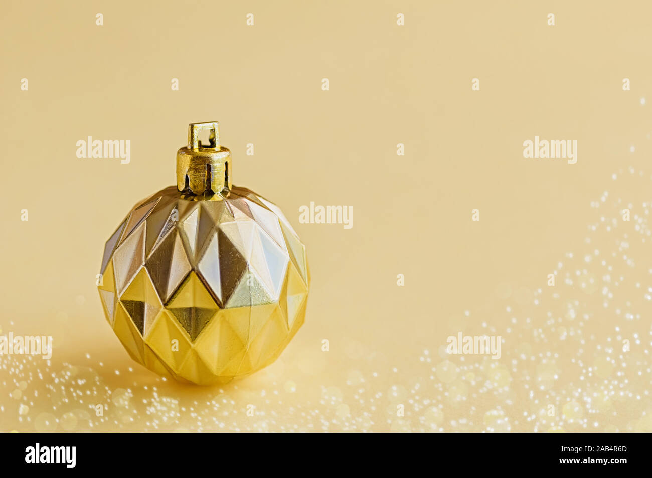 Einen goldenen Dekorative christmas Ball auf einem gelben Hintergrund. Minimalistisches Konzept. Kopieren Sie Platz. Close Up. Stockfoto