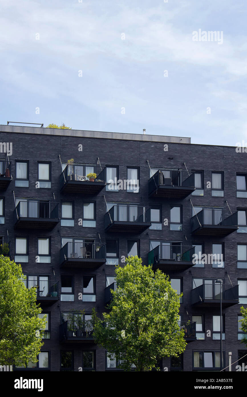 Blick auf Dunkelgrau, modernes Wohnhaus mit Balkon und Bäume in Amsterdam. Es ist ein sonniger Sommertag. Stockfoto