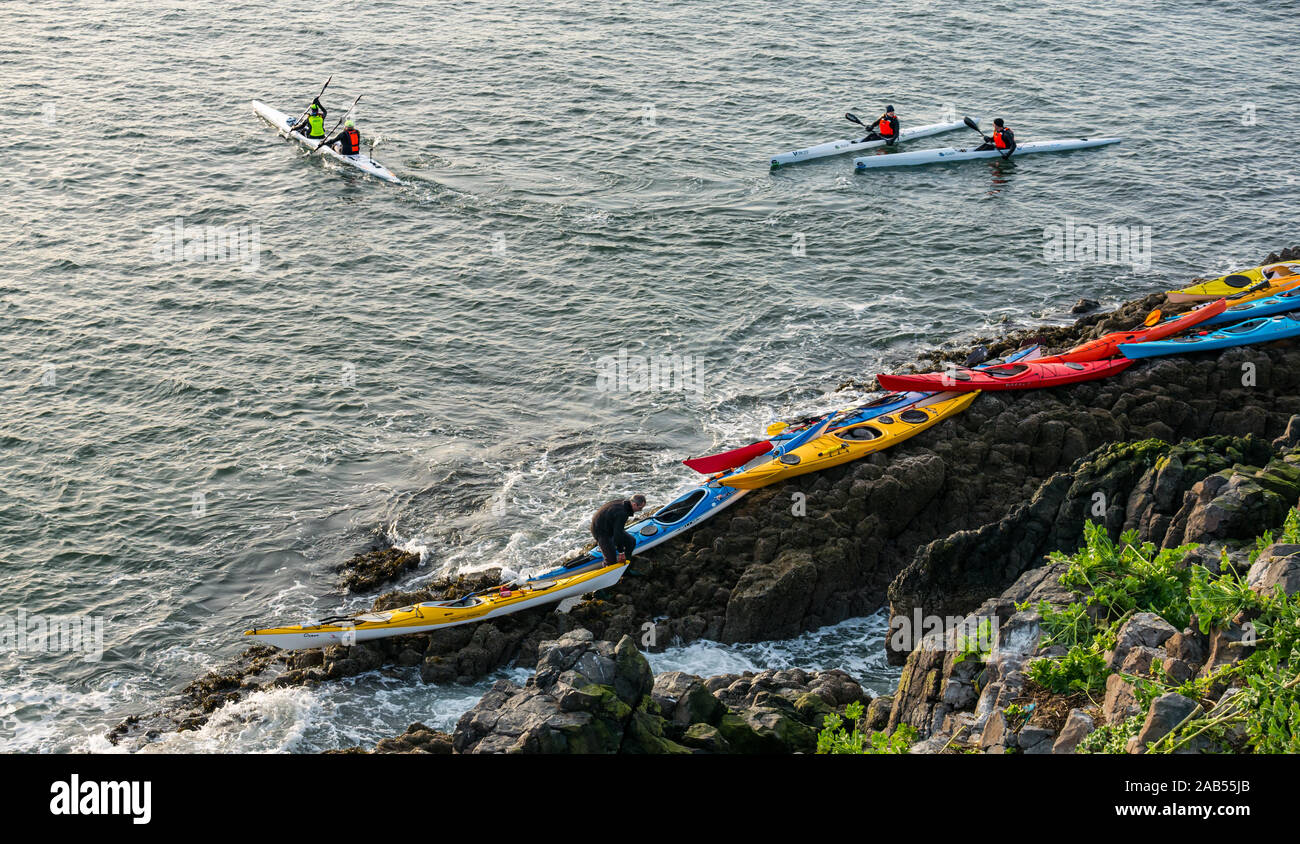 Lothian Sea Kayak Club Kajaks auf felsigen Ufer mit Kajakfahrer in Wasser, Lamm Insel, Erhabene, Schottland, Großbritannien Stockfoto