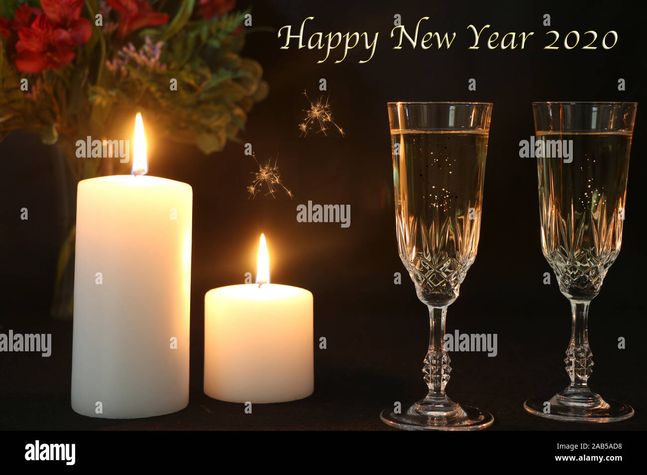 Frohes Neues Jahr 2020 Text mit Kerzen und zwei Champagnergläser Stockfoto