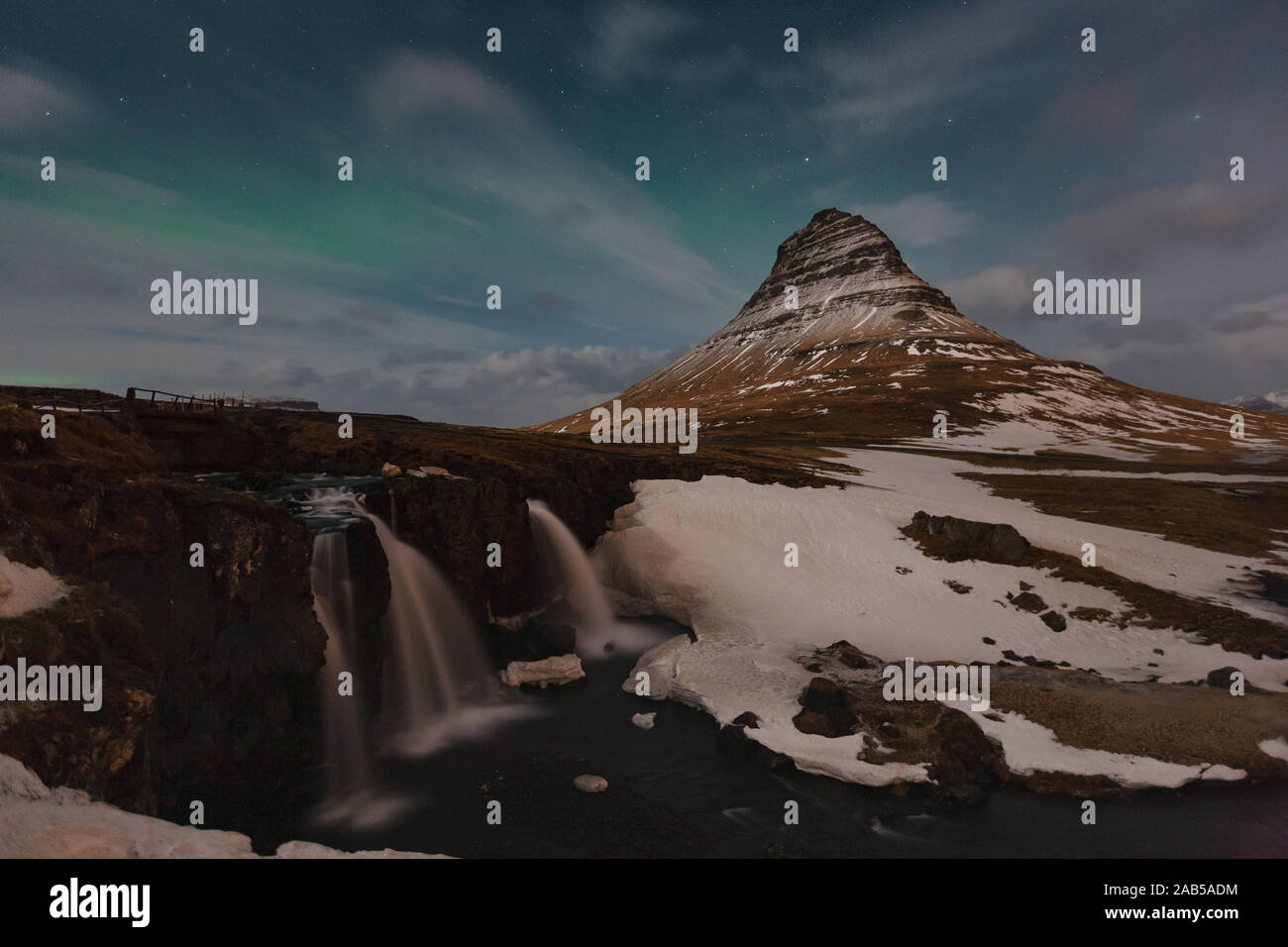 Berühmte Gebirge mit Wasserfällen in Island, Aurora borealis, Nacht, kirkjufell, Winter in Island, Eis und Schnee, Reflexionen, gelben Gras, Natur, ic Stockfoto